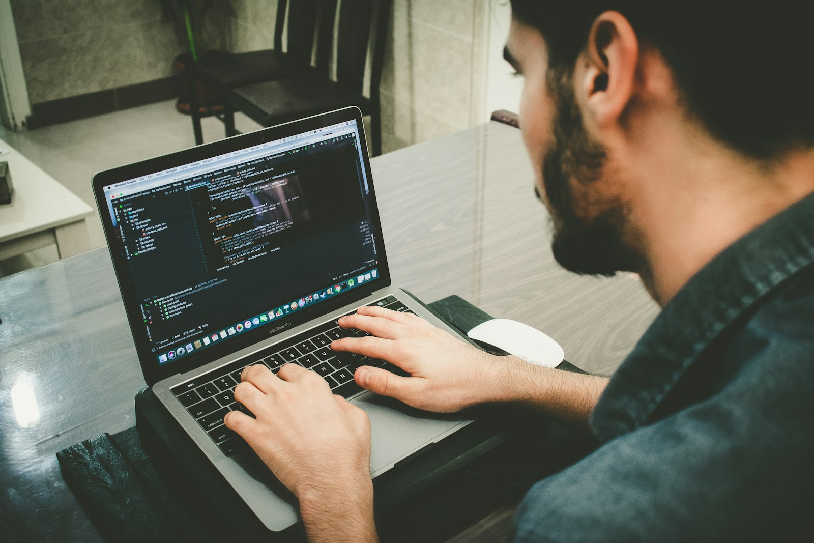 A developer working through code on a laptop at a desk